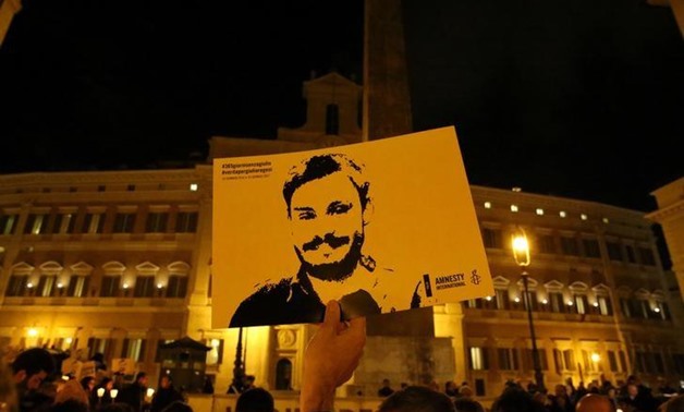A man holds a placard during a vigil to commemorate Giulio Regeni, who was found murdered in Cairo a year ago, in downtown Rome, Italy January 25, 2017.
