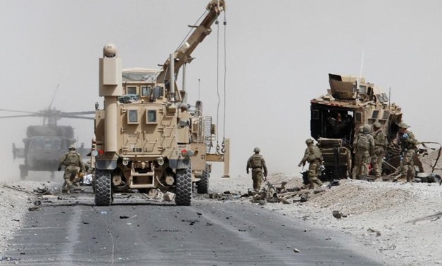 U.S. troops assess the damage to an armoured vehicle of NATO-led military coalition after a suicide attack in Kandahar province. REUTERS/Ahmad Nadeem
