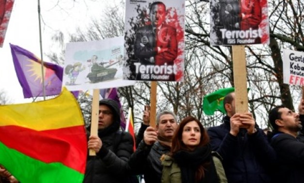 AFP | Kurdish protesters hold placards branding Turkish President Recep Tayyip Erdogan as a "terrorist" over Ankara's offensive in northern Syria