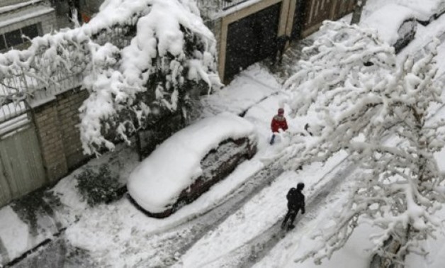 Iranians walk amid the snow in the capital Tehran on January 28, 2018 - AFP