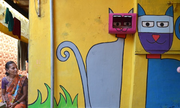 A woman gazes at a mural in a hilltop slum in Mumbai. — Reuters