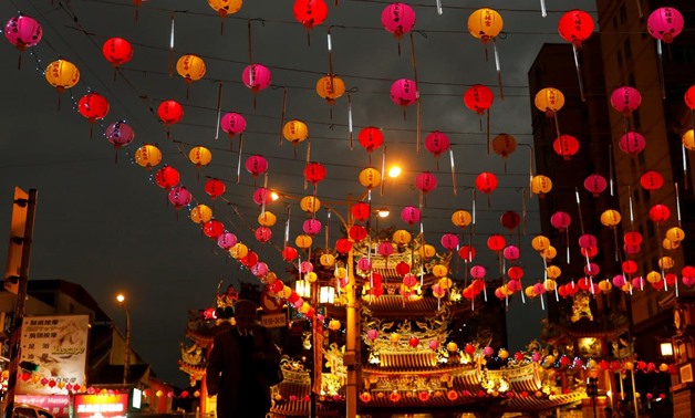 A tourist walks under the lanterns along a street ahead of the Chinese Lunar New Year outside Raohe street Night Market in Taipei, Taiwan Jan. 18, 2017 - Reuters