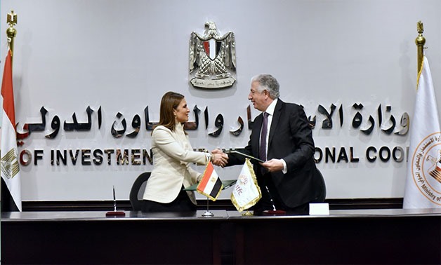 Minister of Investment and International Cooperation Sahar Nasr shakes hand with ITFC CEO Hani Salem Sonbol after signing the agreement in Cairo - Press photo