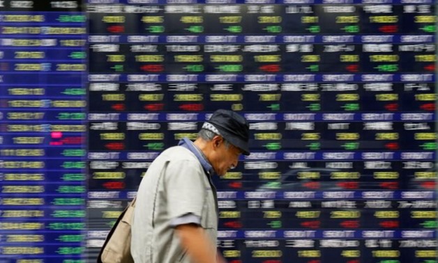 A man walks past an electronic stock quotation board outside a brokerage in Tokyo, Japan, September 22, 2017. REUTERS/Toru Hanai - RC16074E2450
