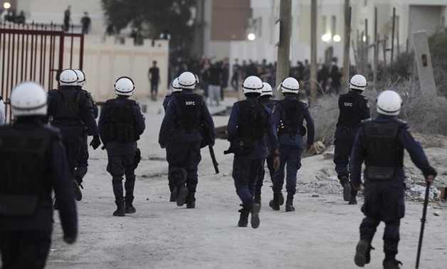 Riot police walk towards protesters during clashes in the village of Daih, west of Manama. REUTERS/Stringer

