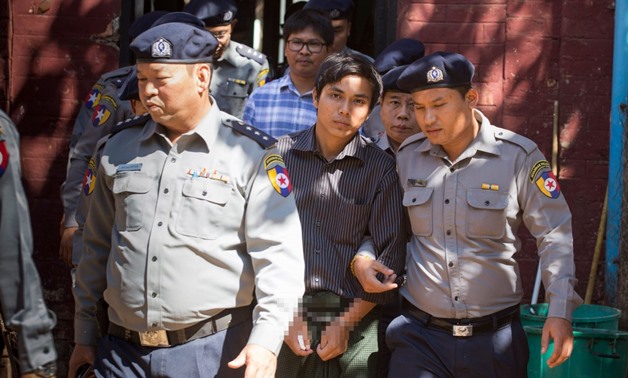 Myanmar police officers escort Reuters journalists Wa Lone (back, C) and Kyaw Soe Oo (C) at a previous hearing in the northern district court in Yangon on January 23, 2018 - AFP
