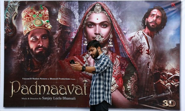A cinemagoer takes a selfie in front of a poster of Bollywood movie "Padmaavat" outside a movie theatre in Kochi, India, January 25, 2018. REUTERS/Sivaram V
