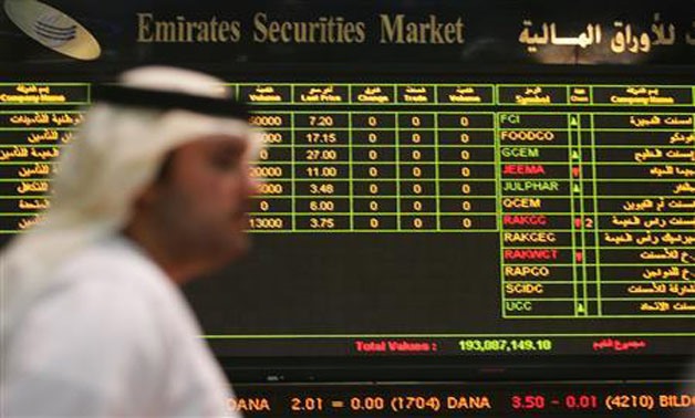 A file photo of a trader walking past the quotation board at the Abu Dhabi stock market, July 11, 2006 - Reuters/Ravindranath
