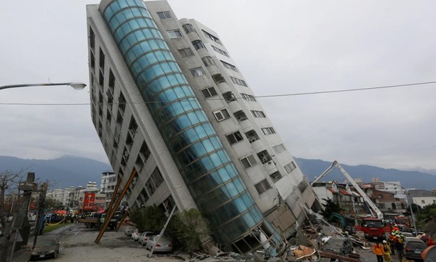Rescue workers are seen by a damaged building after an earthquake hit Hualien, Taiwan February 7, 2018 / REUTERS/Stringer