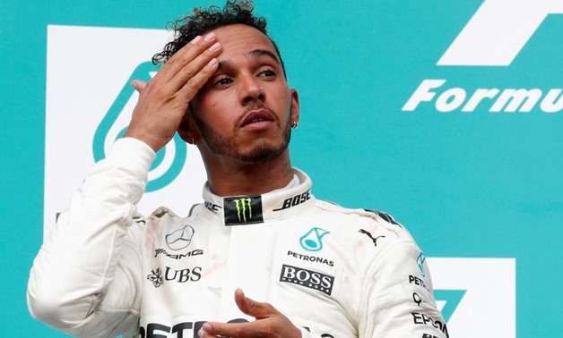Formula One F1 - Malaysia Grand Prix - Sepang, Malaysia - October 1, 2017. Mercedes' Lewis Hamilton wipes his forehead on the podium. REUTERS/Edgar Su