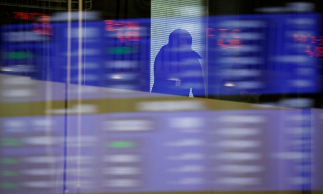 A visitor is seen as market prices are reflected in a glass window at the Tokyo Stock Exchange (TSE) in Tokyo, Japan, February 6, 2018. REUTERS/Toru Hanai
