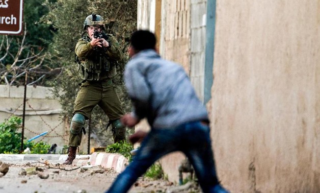 A Palestinian protester confronts an Israeli soldier during an army search operation in the Palestinian village of Burqa, about 18 kilometres northwest of Nablus in the occupied West Bank, on February 3, 2018. Jaafar Ashtiyeh / AFP
