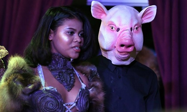 After walking the runway, eight models took to the microphone next to a man wearing pig's mask to share their experience of sexual harassment or assault - AFP / ANGELA WEISS