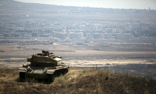 The Syrian area of Quneitra is seen in the background as an Israeli tank parks on a hill, near the ceasefire line between Israel and Syria, in the Israeli-occupied Golan Heights – REUTERS