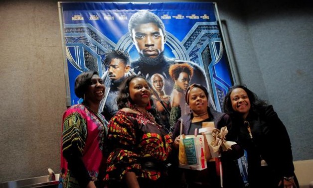 FILE PHOTO: A group of women pose for a photo in front of a poster advertising the film "Black Panther" on its opening night of screenings at the AMC Magic Johnson Harlem 9 cinemas in Manhattan, New York, U.S., February 15, 2018. REUTERS/Andrew Kelly
