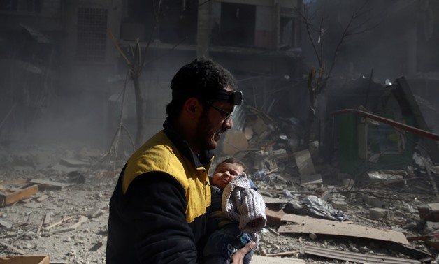 A Civil defence member reacts as he holds a baby after an airstrike in the besieged town of Douma in eastern Ghouta in Damascus, Syria, February 7, 2018. REUTERS/ Bassam Khabieh