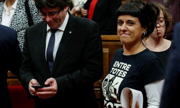 FILE PHOTO: Leftist CUP party member Anna Gabriel (R) walks past Catalan President Carles Puigdemont during a debate in the Catalan regional parliament in Barcelona, Spain, October 10, 2017 / REUTERS/Albert Gea/File Photo