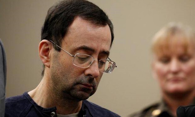 FILE PHOTO: Larry Nassar, a former team USA Gymnastics doctor who pleaded guilty in November 2017 to sexual assault charges, stands with his legal team during his sentencing hearing in Lansing, Michigan, U.S., January 24, 2018. REUTERS/Brendan McDermid
