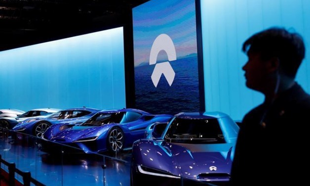 FILE PHOTO: A man is silhouetted in front of Nio cars at the auto show, in Shanghai, China April 20, 2017. REUTERS/Aly Song/File Photo
