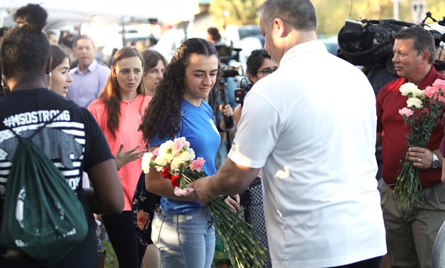 Students receive donated flowers as they arrive at Marjory Stoneman Douglas High School for the first time since the mass shooting in Parkland, Florida, U.S., February 28, 2018. REUTERS/Mary Beth Koeth
