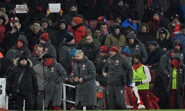 Soccer Football - Premier League - Arsenal vs Manchester City - Emirates Stadium, London, Britain - March 1, 2018 Arsenal manager Arsene Wenger looks dejected at the end of the match as fans hold up banners Action Images via Reuters/Tony O'Brien 