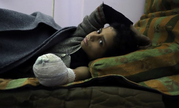 Syrian child Khaled al-Ghorani lies at a clinic in Eastern Ghouta on March 1, 2018 after his hand was amputated
