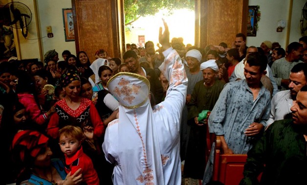 A Coptic Christian priest blesses his congregation with holy water during Sunday service in the Virgin Mary Church at Samalout Diocese in Al-Our village, in Minya governorate, south of Cairo, May 3, 2015. - REUTERS/Stringer