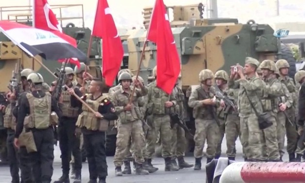 Iraqi and Turkish soldiers wave flags at the Habur Border Gate between Turkey and Iraq in this still image taken from video, October 31, 2017.