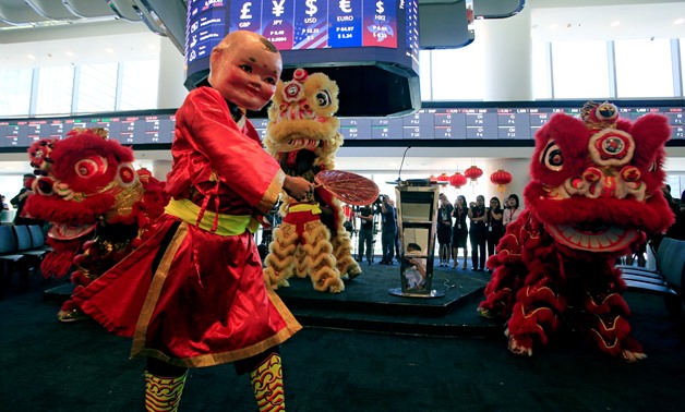 A dancer wearing a Chinese "Big Head Buddha" costume performs along with a Dragon dance during the opening bell ringing to mark the first trading day at the brand new Philippine Stock Exchange complex in Bonifacio Global city, the capital's newest financi