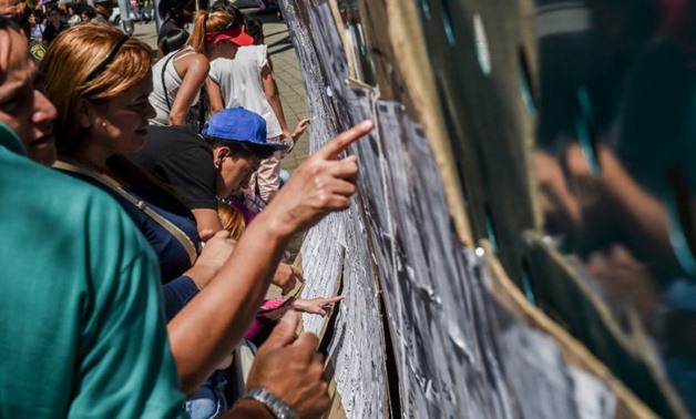 Colombian voters check the electoral rolls Sunday at a polling station in Medellin during elections to select a new Congress, with rightist candidates, bitterly opposed to the peace deal with leftist rebels, expected to do well
