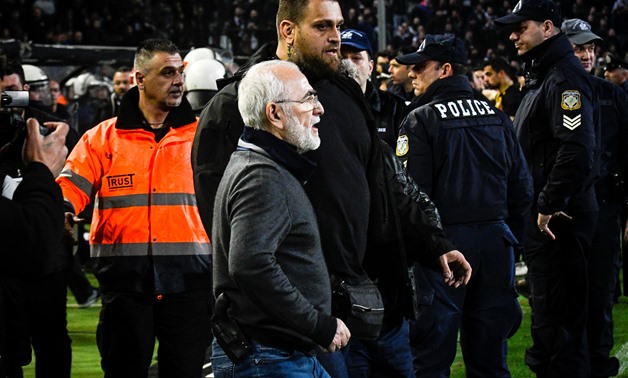Russian-born Greek businessman and owner of PAOK Salonika, Ivan Savvides (C), pictured with what appears to be a gun in a holster, enters the pitch after the referee annulled a goal of PAOK during their soccer match against AEK Athens in Toumba Stadium in