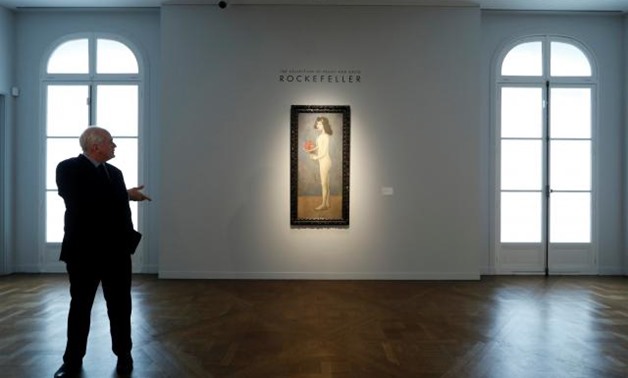 Christie's employees stand next to 'Fillette a la corbeille fleurie' by Pablo Picasso from the collection of Peggy and David Rockefeller during a sale preview at Christie's auction house in Paris, France March 13, 2018. Picture taken March 13, 2018. REUTE