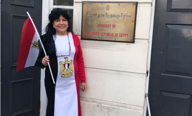 A woman voter wearing a dress of the three Egyptian flag colours outside the Egyptian embassy in London to cast her vote in Presidential election - Egypt Today
