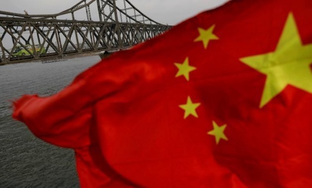 A Chinese flag is seen in front of the Friendship bridge over the Yalu River connecting the North Korean town of Sinuiju and Dandong in China's Liaoning Province on April 1, 2017 - REUTERS/Damir Sagolj/File Photo