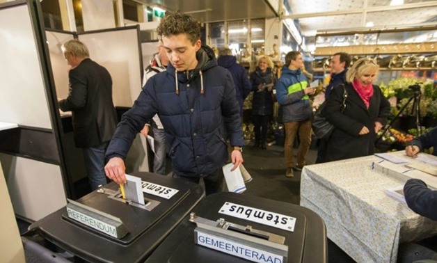 A man casts his vote during the start of local Dutch elections at the train station in Castricum on Wednesday
- AFP