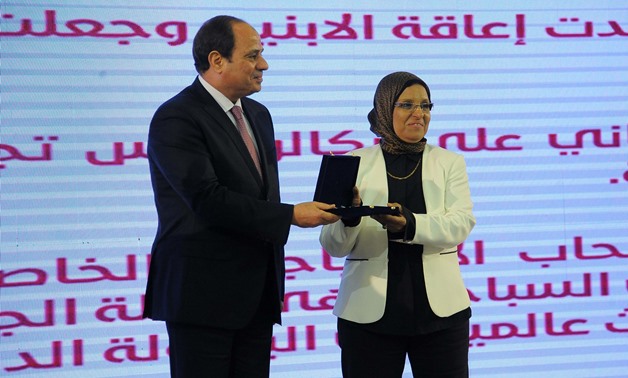  President Abdel Fatah Al Sisi honors one of the women that were honored at the Mother's Day ceremony on Wednesday - Press photo