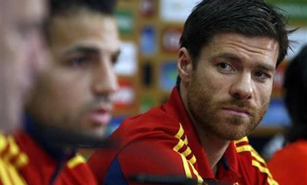 Spain's national soccer player Xabi Alonso (R) looks at his team mate Cesc Fabregas as they attend a news conference during the Euro 2012 soccer tournament in Gniewino, June 25, 2012. REUTERS/Kacper Pempel