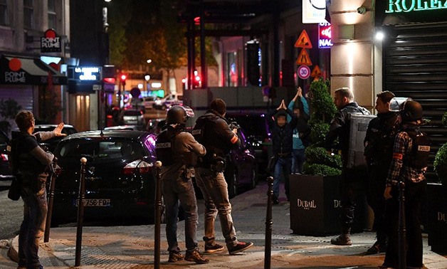 Police check passersby near the Champs Elysees in Paris after a shooting - AFP