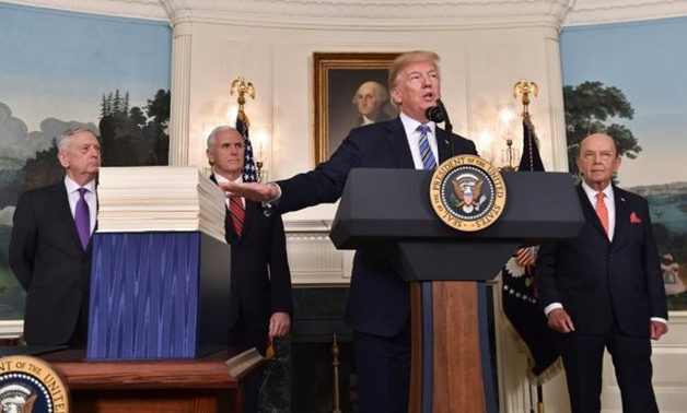 US President Donald Trump -- flanked by (L to R) Pentagon chief Jim Mattis, Vice President Mike Pence and Commerce Secretary Wilbur Ross -- speaks after signing a $1.3 trillion spending bill - AFP
