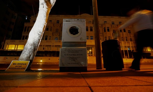 A washing machine and a mock plaque commemorating the opening of Pilatus Bank by Maltese Prime Minister Joseph Muscat in 2014, which was left outside Whitehall Mansions, which houses the Maltese-registered Pilatus Bank, whose Iranian chairman Ali Sadr Has