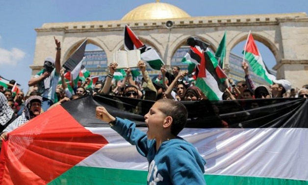 A Palestinian boy shouts slogans as others wave flags during a protest to mark Nakba day near the Dome of the Rock in Jerusalem's Old City, May 15, 2015. (Reuters)
