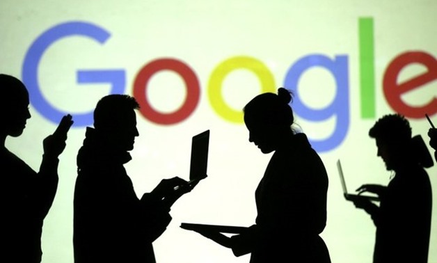 Silhouettes of laptop and mobile device users are seen next to a screen projection of Google logo in this picture illustration taken March 28, 2018. REUTERS/Dado Ruvic/IllustrationREUTERS

