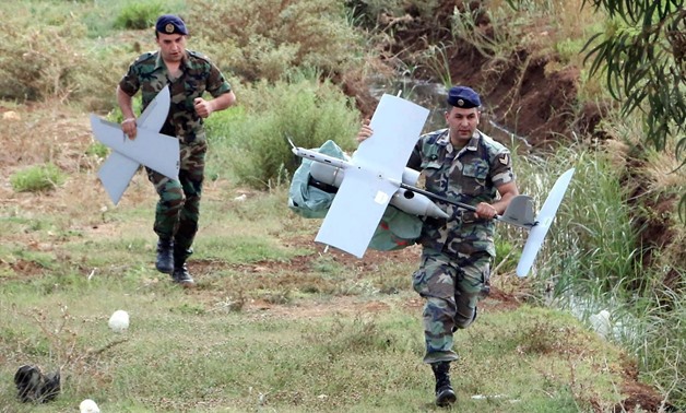 Lebanese Army soldiers carry parts of an Israeli drone that crashed in the Marjeyoun countryside, south Lebanon, Sept. 20, 2014.Reuters