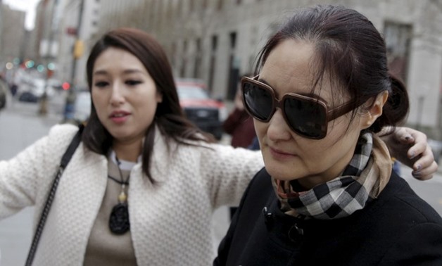 Julia Vivi Wang, (R) who is accused of having paid a bribe for diplomatic positions, exits the Manhattan U.S. District Courthouse in New York - Reuters
