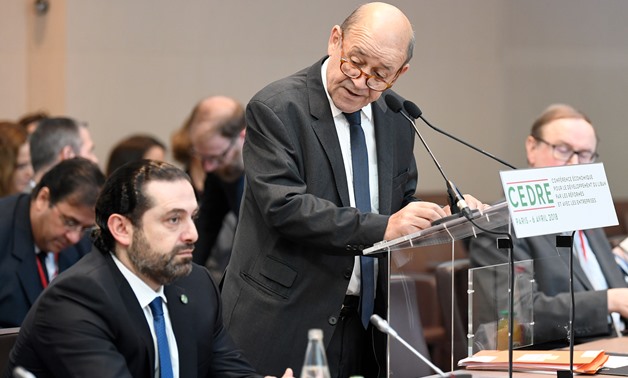 French Foreign Minister Jean-Yves Le Drian delivers his opening speech as Lebanese Prime Minister Saad Hariri (L) listens to during the Cedar (CEDRE) Conference for international donors and investors to support Lebanon's economy, in Paris, France, April 6