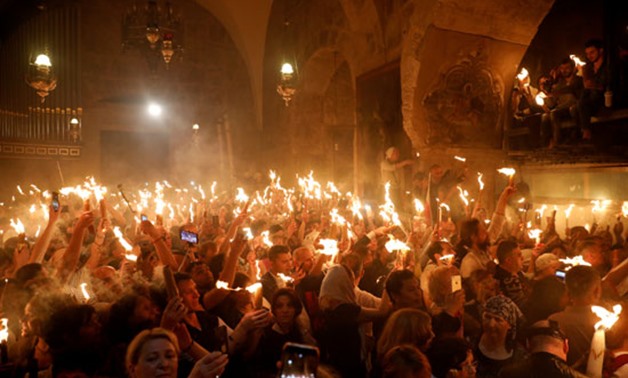 Christians celebrate Holy Saturday by holding up candles lit from the 'Holy Fire' in the Church of the Holy Sepulchre in Jerusalem's old city - file.jpg