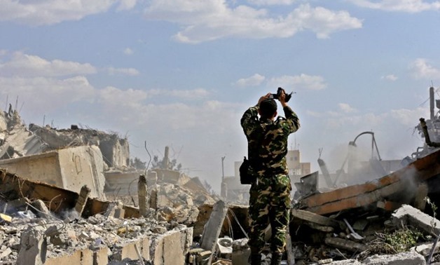 A Syrian soldier inspects the wreckage of a building described as part of the Scientific Studies and Research Centre (SSRC) compound in the Barzeh district north of Damascus, during a press tour organised by the Syrian government after US-led strikes (AFP