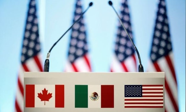 The flags of Canada, Mexico and the U.S. are seen on a lectern before a joint news conference on the closing of the seventh round of NAFTA talks in Mexico City, Mexico March 5, 2018. REUTERS/Edgard Garrido