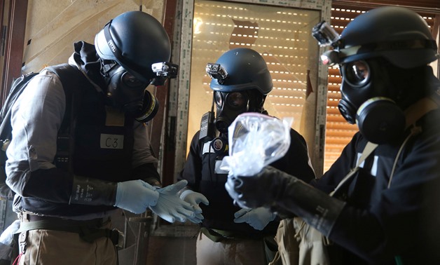 EVIDENCE: A U.N. chemical weapons expert holds samples from one of the sites of a chemical weapons attack in the Ain Tarma neighbourhood of Damascus in August, 2013. REUTERS/Mohamed Abdullah