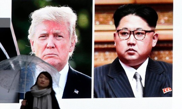 An electronic screen showing President Trump and the North Korean leader, Kim Jong-un, on Friday in Tokyo - AFP